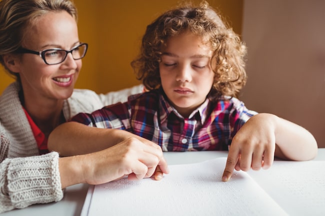 A blind boy learning to read Braille A blind boy learning to read Braille